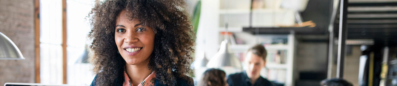 Business woman in office with coworkers in background