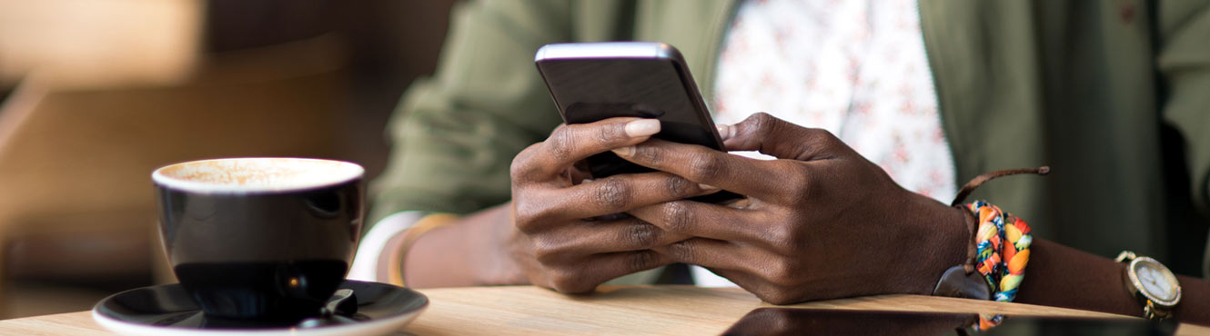 Woman holding phone at coffee shop